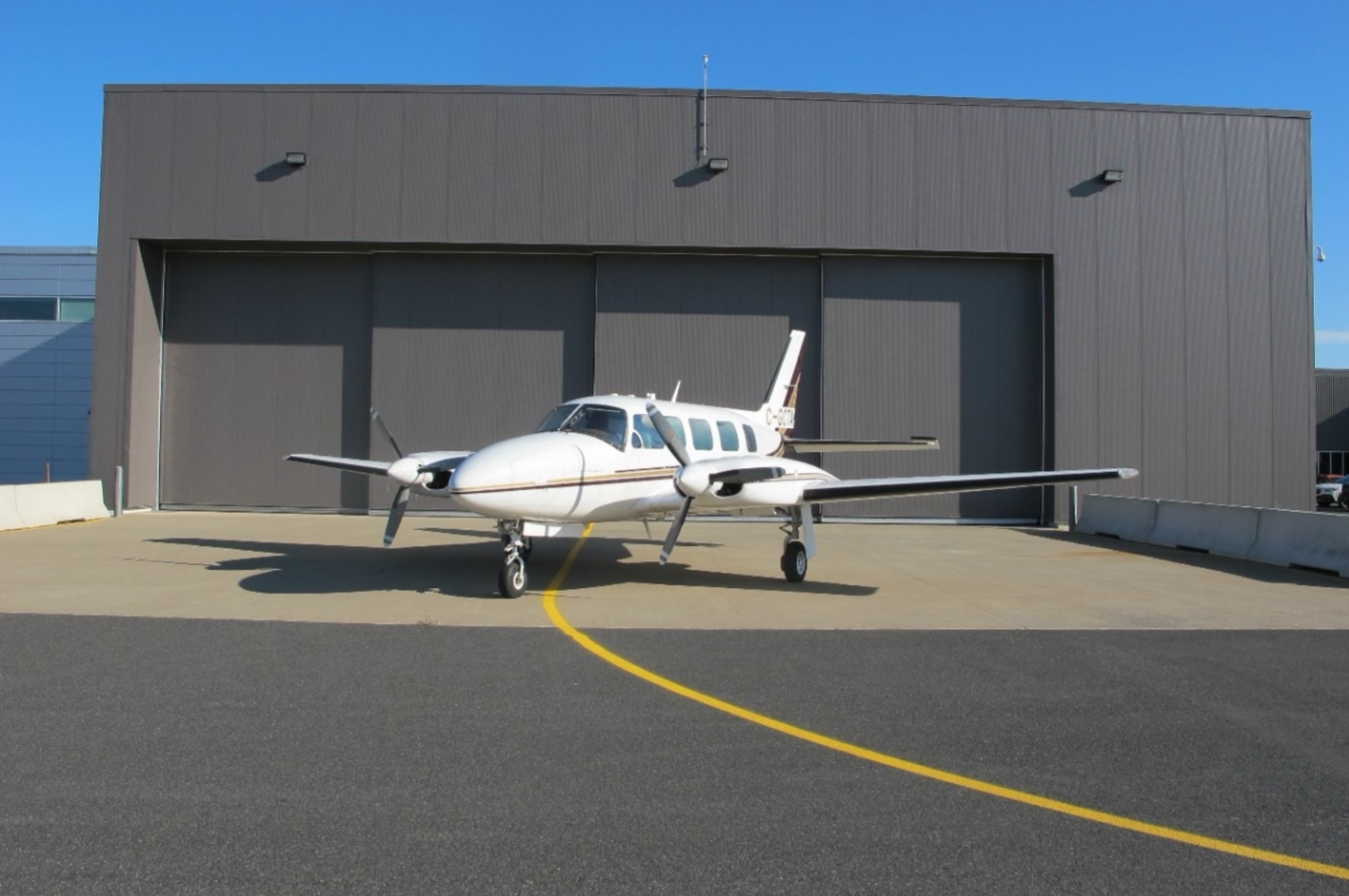 Avion d’essai bimoteur Piper PA-31-350 Chieftain devant hangar