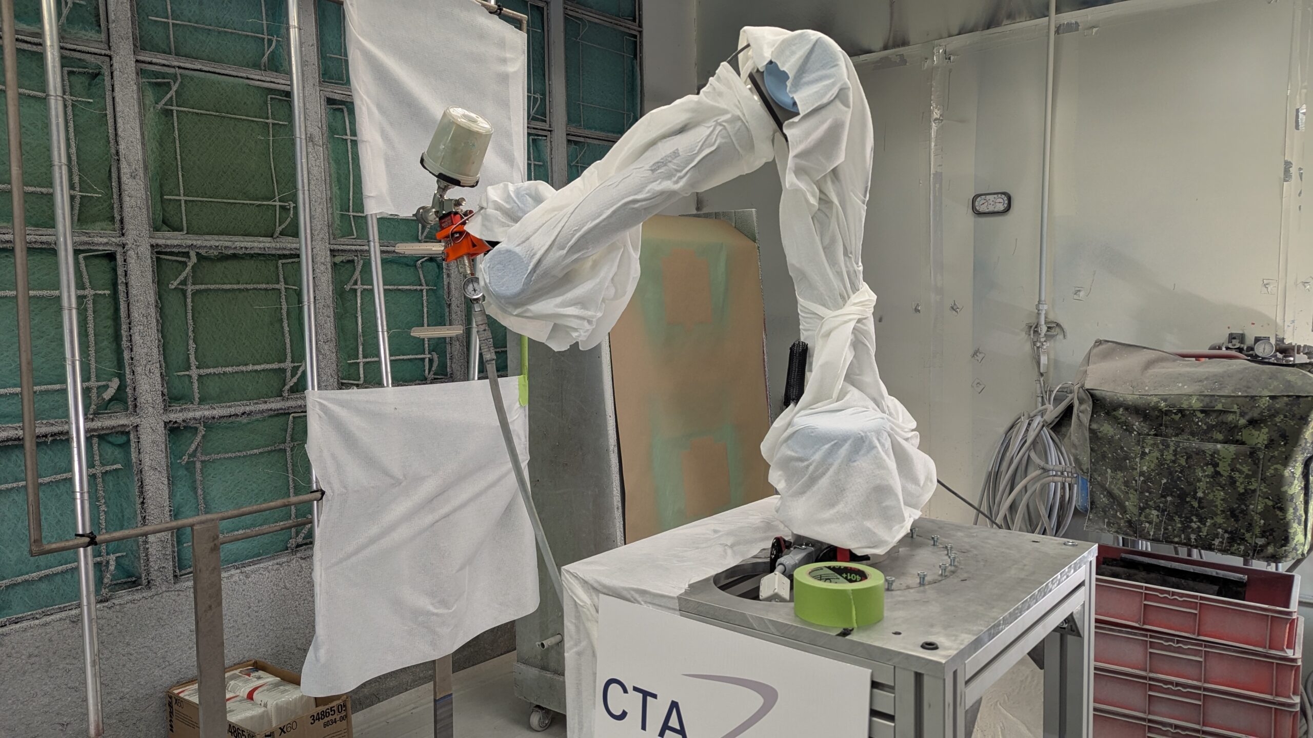 Robot téléopéré pour peinture dans une cabine industrielle.